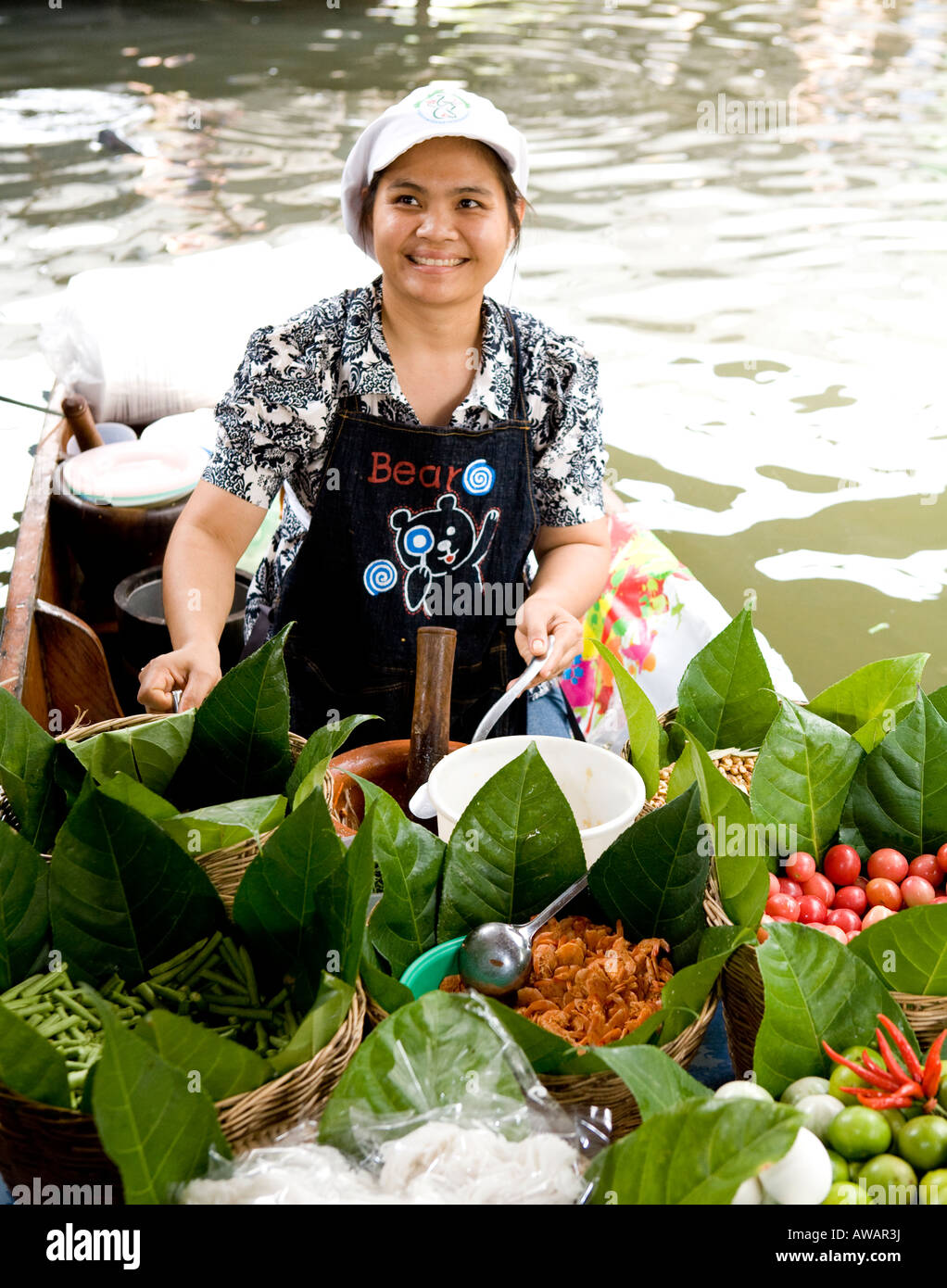 Donna Thai Vendita di merci in una Bangkok mercato galleggiante della Thailandia del sud-est asiatico Foto Stock