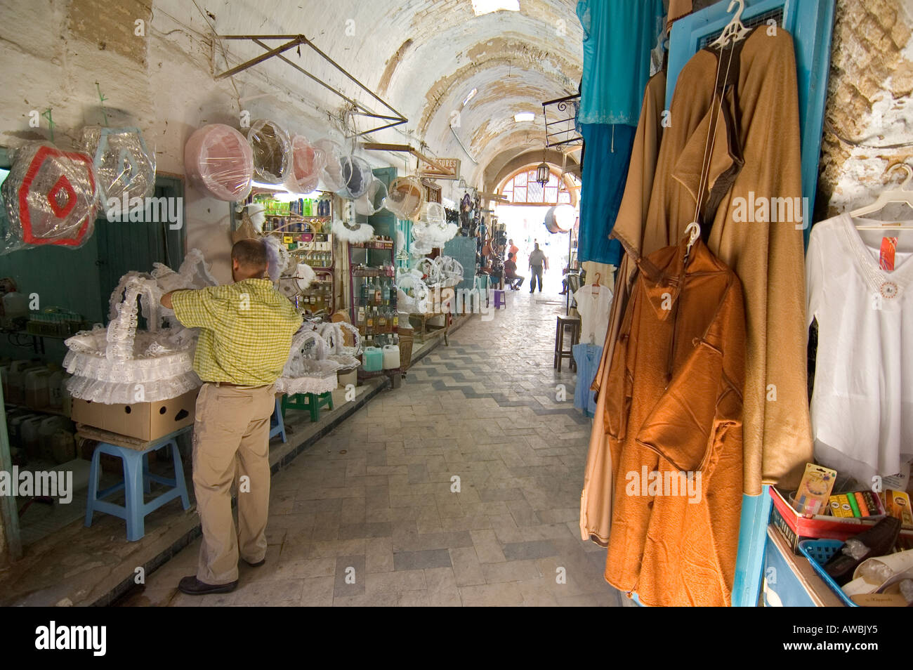 Abiti tradizionali per la vendita all'interno di un vicolo di Kairouan souk mercato, Tunisia. Foto Stock