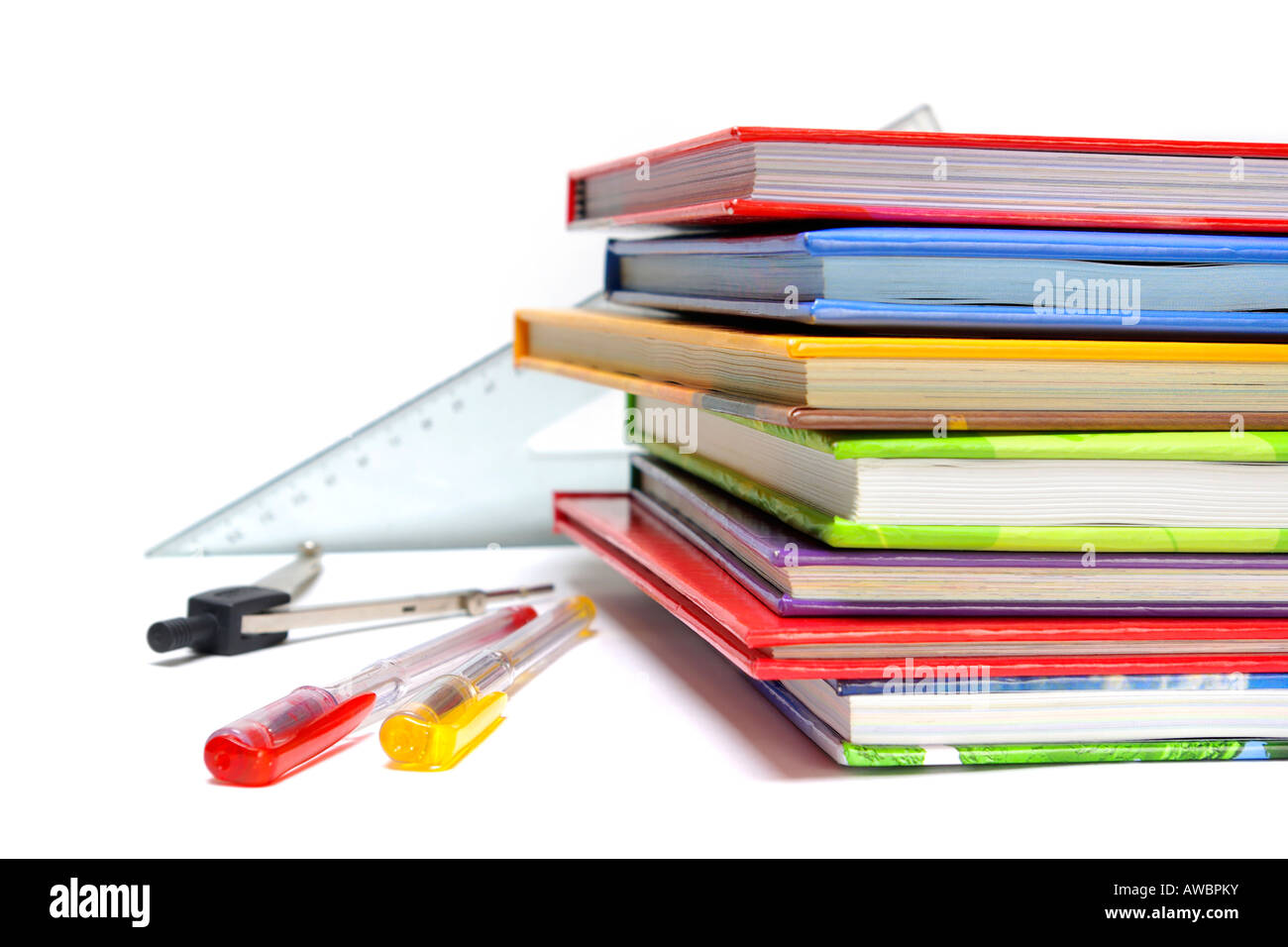Penne righelli bussola e pila di libri colorati isolato su bianco Foto Stock