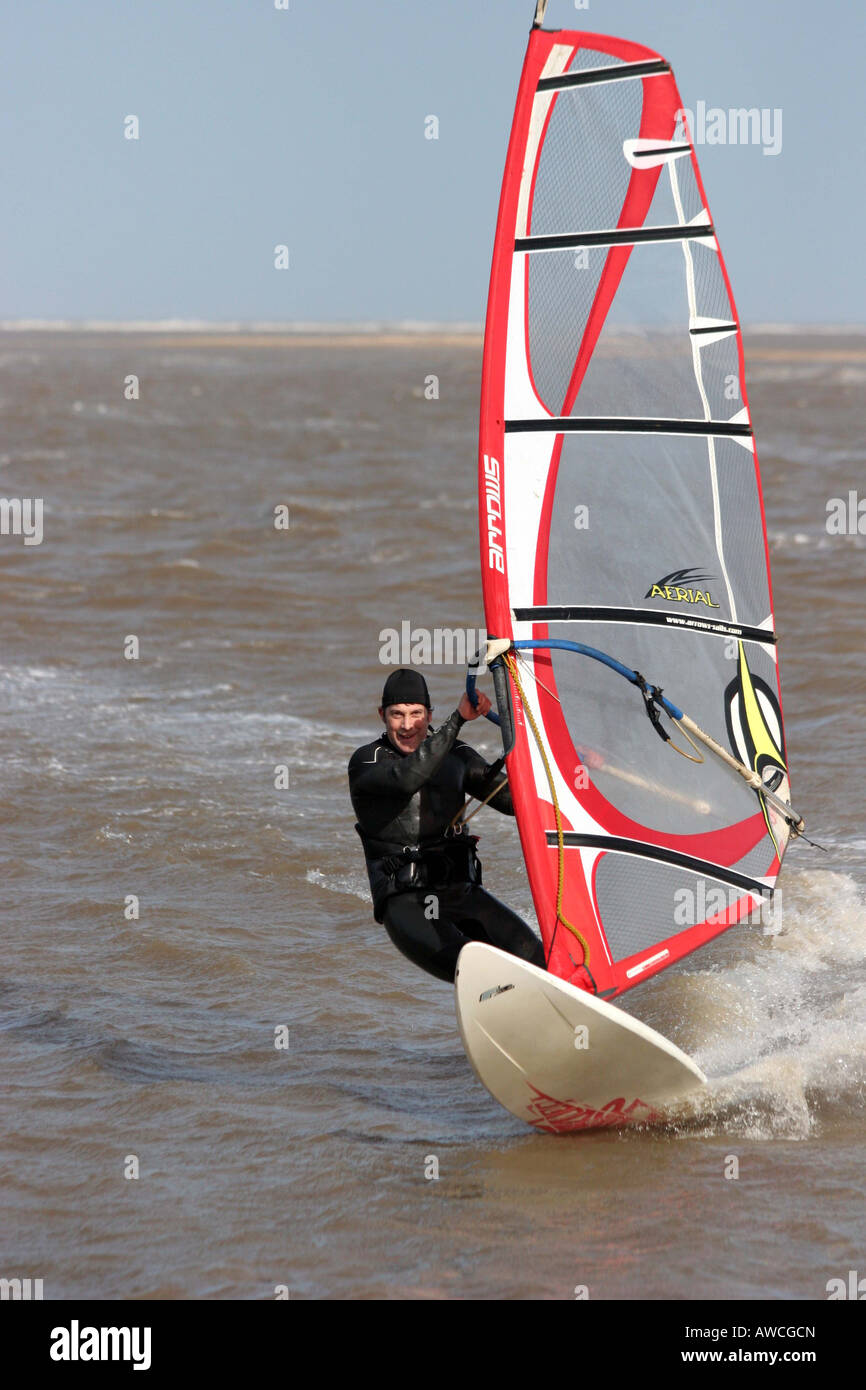 Windsurf con un red sail volare sopra le onde Foto Stock