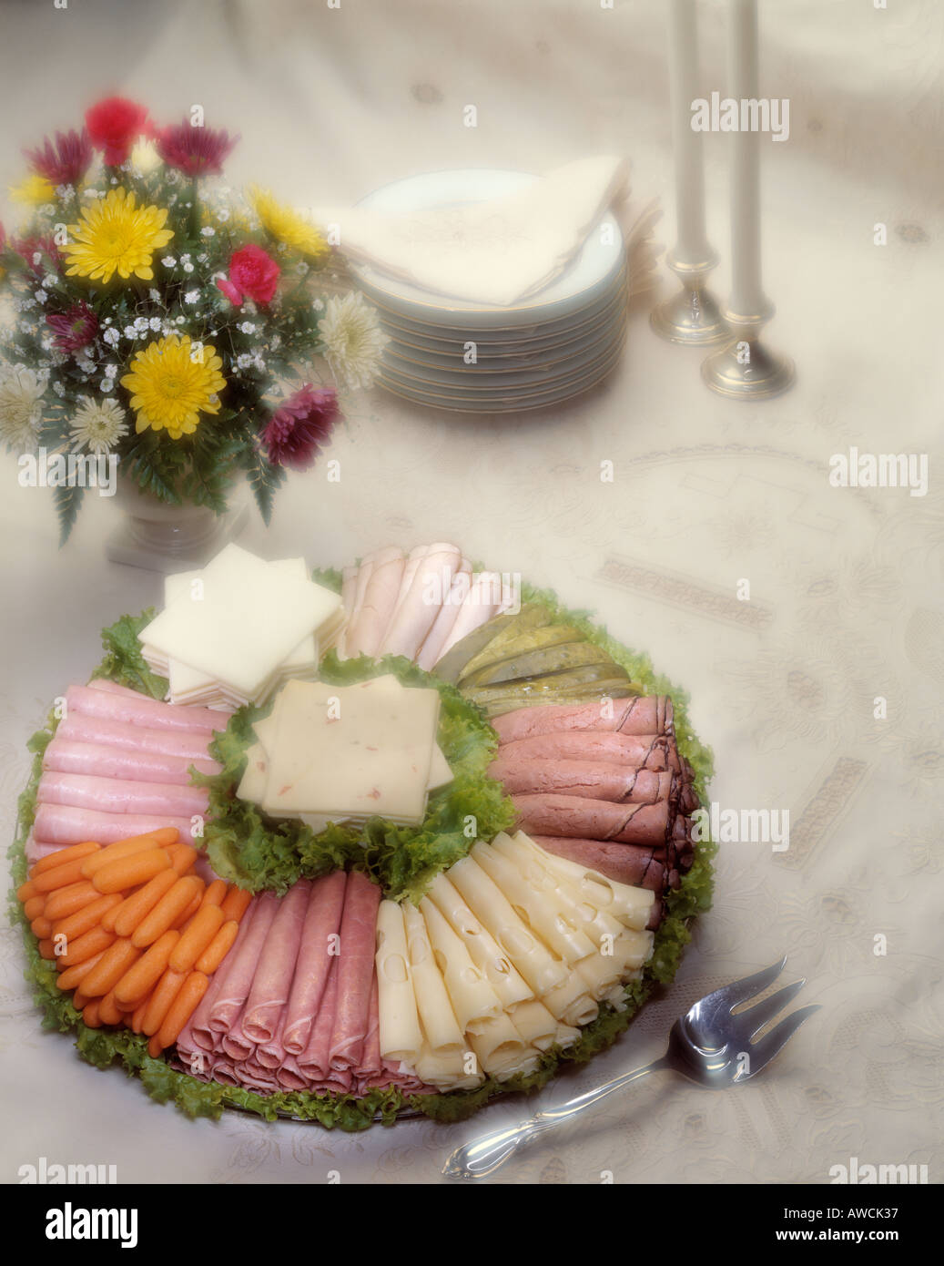 Fancy deli assortimento piatto di formaggio svizzero roast beef prosciutto turchia carote sottaceti pepe formaggio lattuga boquet floreali soft focus Foto Stock