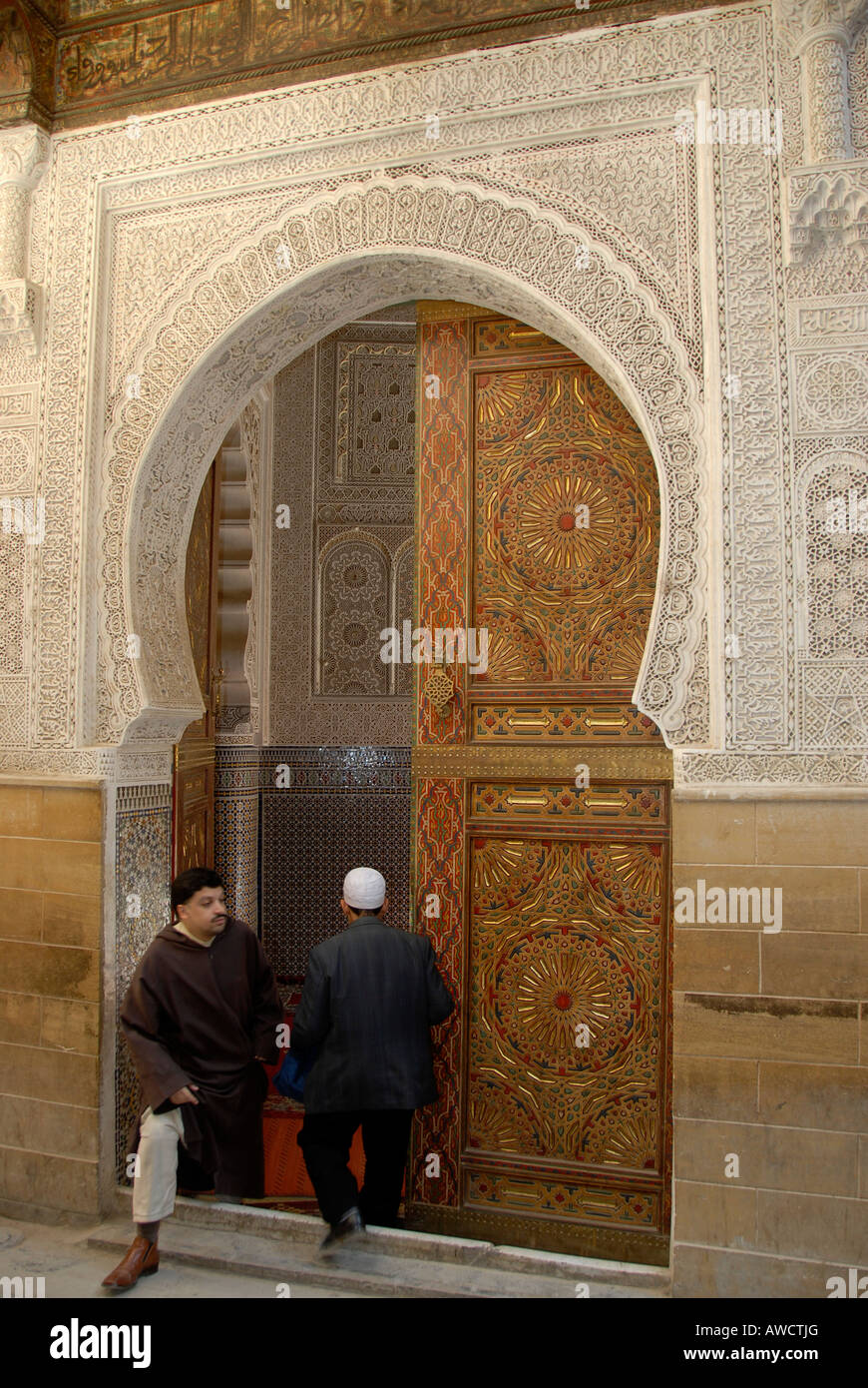 Uomini locale a un decorato cancello di ingresso ad una moschea Fes el Bali Marocco Foto Stock