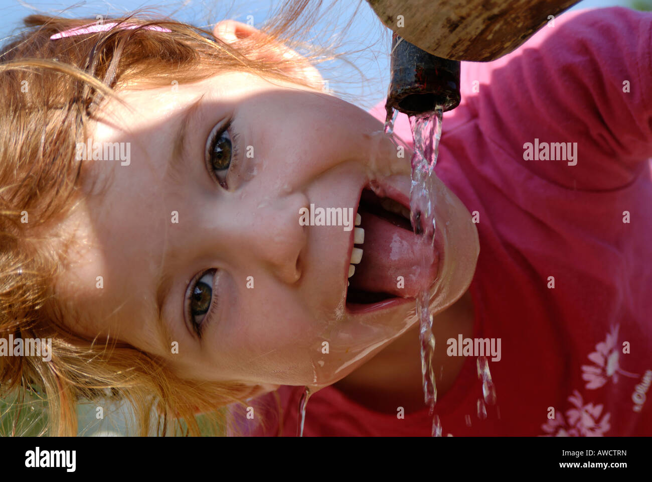 Bambino di bere acqua naturale da una fontana Foto Stock