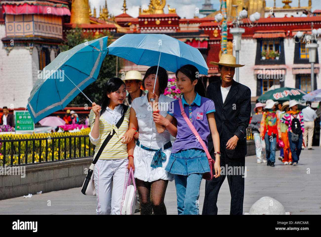 Tre giovani donne cinesi con sun ombrelloni, Barkor, Lhasa, in Tibet Foto Stock
