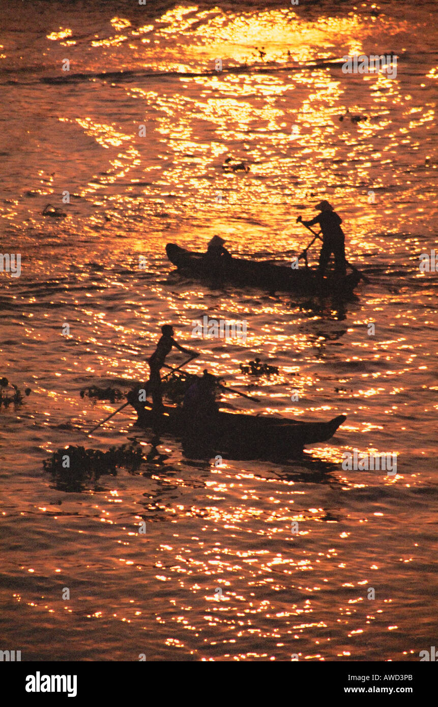 Barche che attraversa il fiume Mekong all'alba Foto Stock