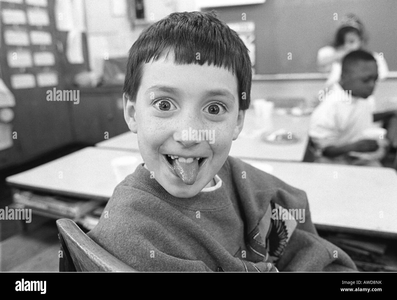 Scuola elementare bambino facendo una faccia per la fotocamera Foto Stock