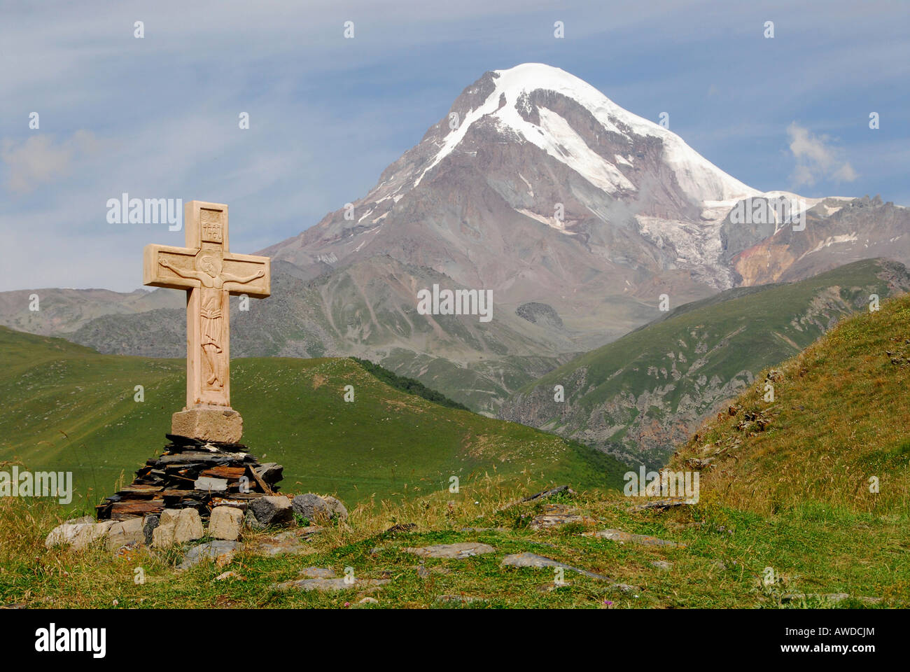 Croce alla Chiesa Gergeti, Mt. Kazbegi (5047 m o 16558 ft) in background, vicino a Kazbegi, Georgia, Asia Foto Stock