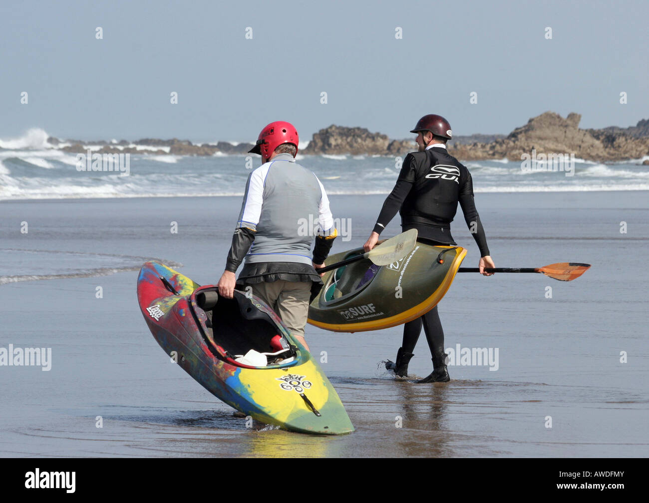 Due uomini carring loro surf kayak verso il mare Foto Stock