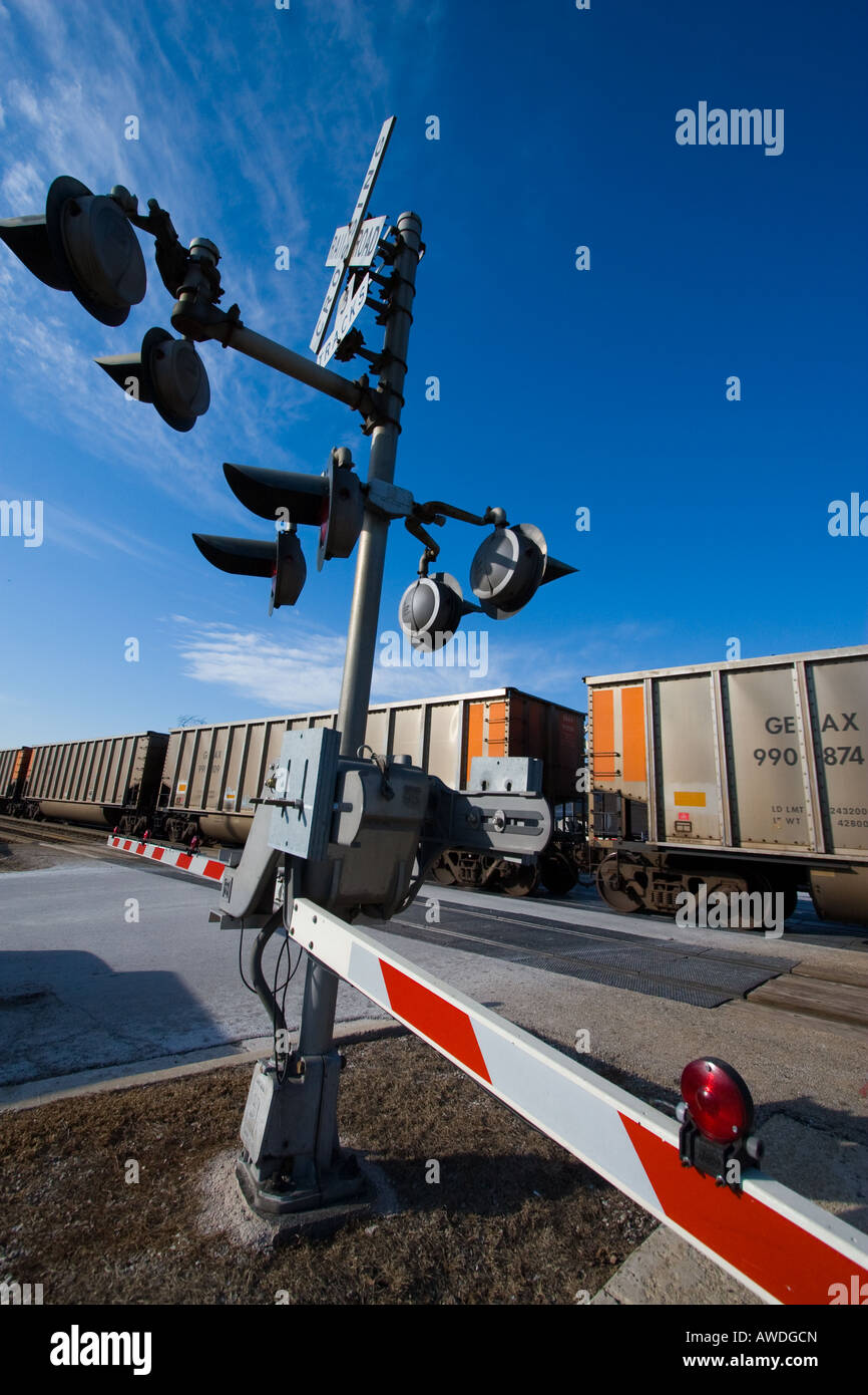 Un carbone treno passa una traversata di barriera di protezione in Chicago suburbana. Foto Stock