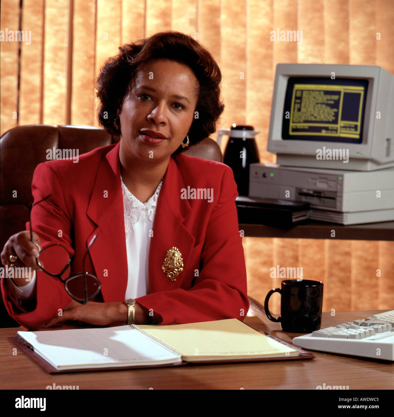 1 una femmina business executive office computer afro americano africano istruzione educatore red suit jacket gesto bicchieri Foto Stock