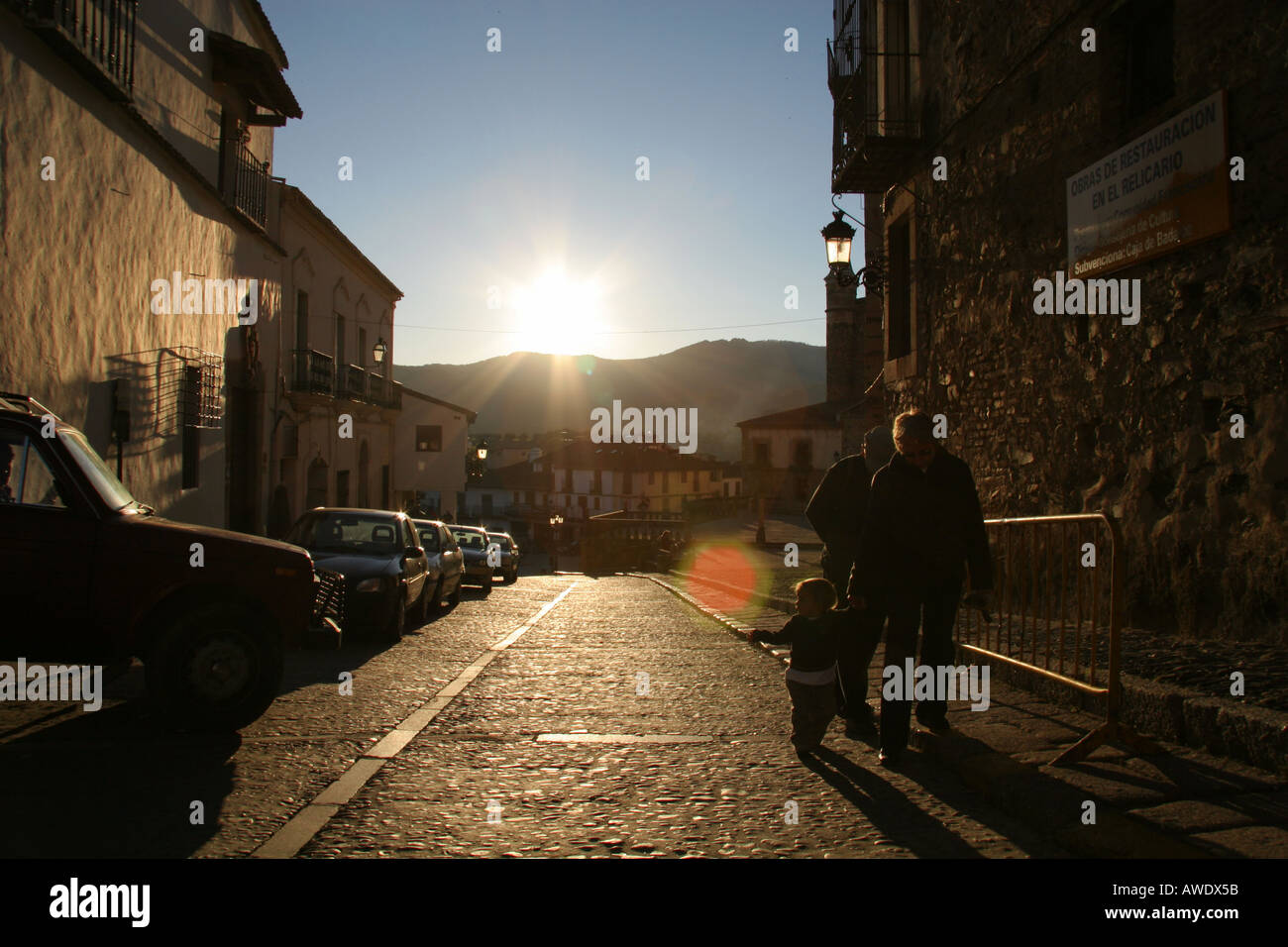 Una famiglia a piedi fino alla strada con il sole brilla dietro, Guadalupe Extremadura Spagna Foto Stock