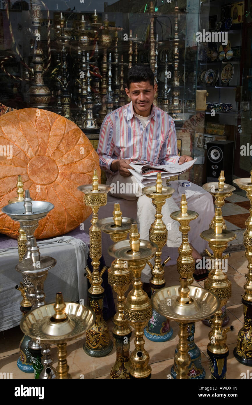 L'uomo vendere shisha pipe e cuscini in pelle da fuori il suo negozio a Sharm vecchia Sinai Egitto Foto Stock