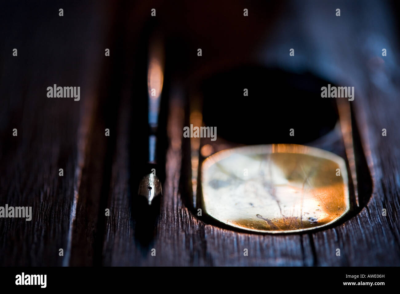 Vecchia scuola di legno scrivania con un inchiostro e penna stilografica illuminato a lume di candela. Cumbria, Regno Unito Foto Stock