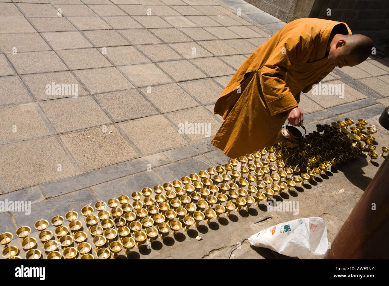 Un monaco riempie la preghiera luci con olio con per il tempio. Wutai Shan, Repubblica Popolare di Cina Foto Stock