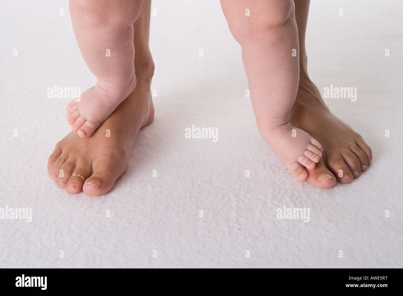 Due piedi del bambino su due piedi grandi Foto Stock