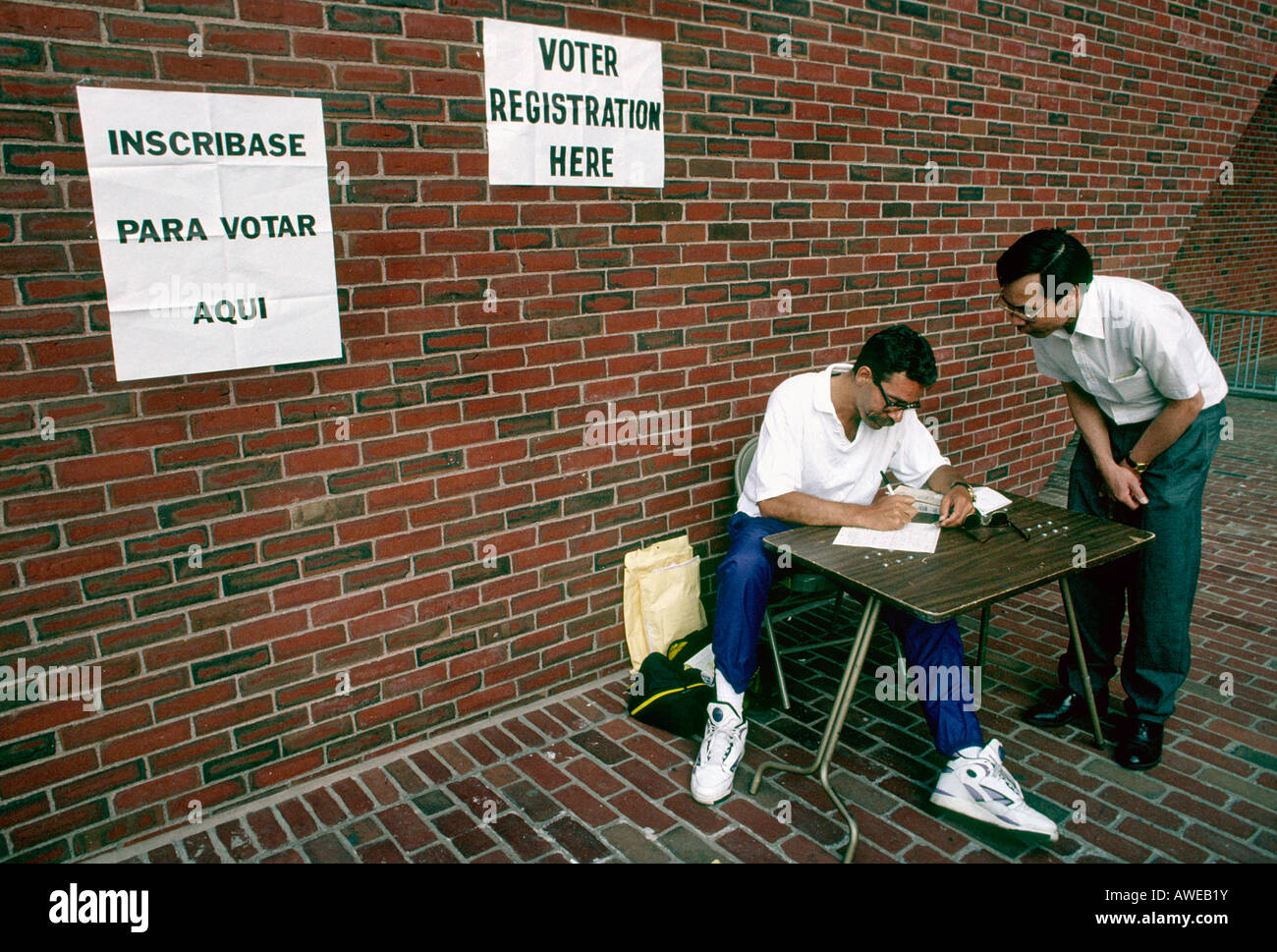 Un volontario che aiuta un uomo asiatico a un elettore Tabella di registrazione impostato al di fuori del municipio di Boston, Massachusetts. Foto Stock