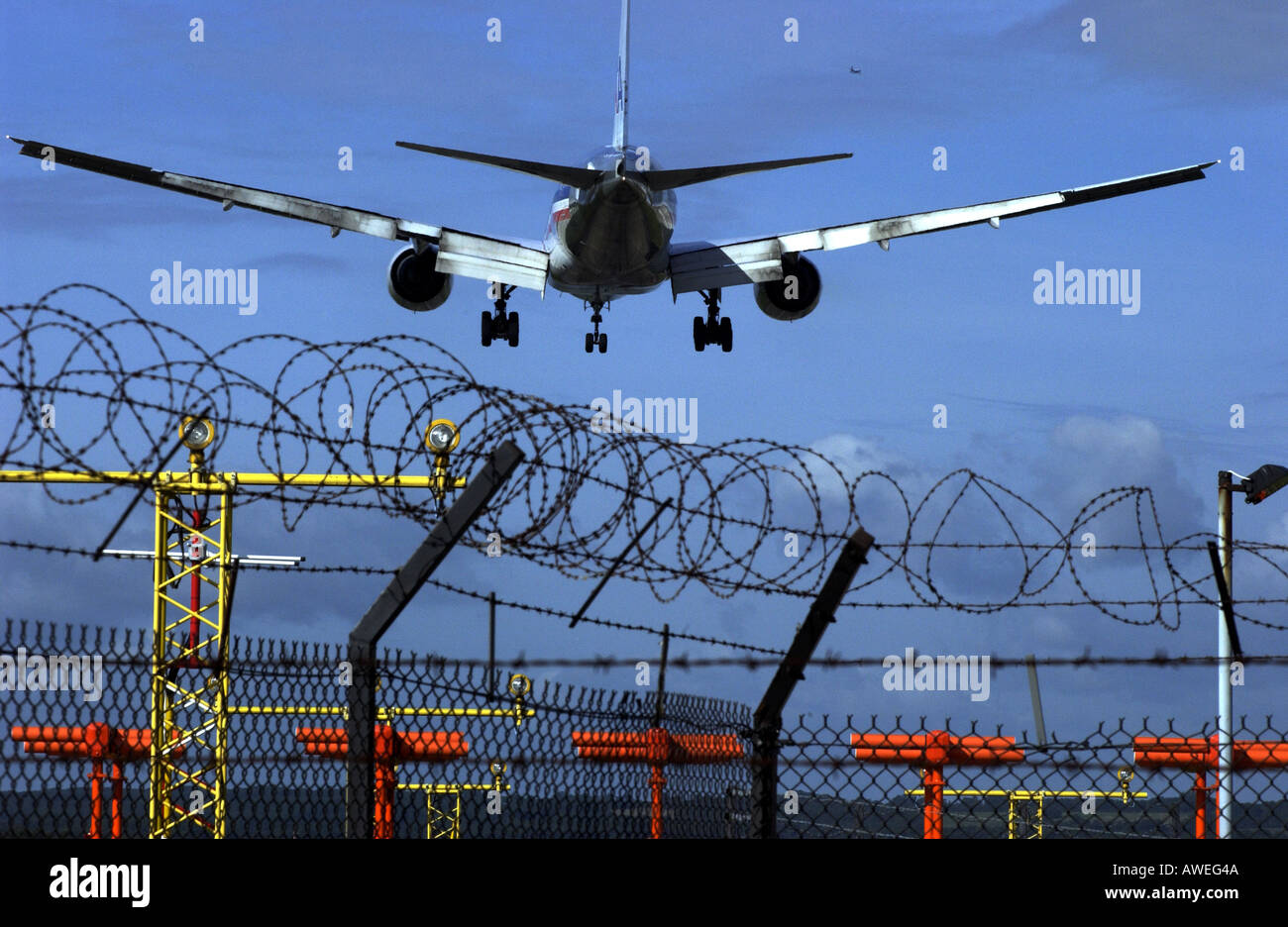 American Airlines Airbus jet entra in terra a Gatwick oltre il filo spinato recinzioni perimetrali Foto Stock
