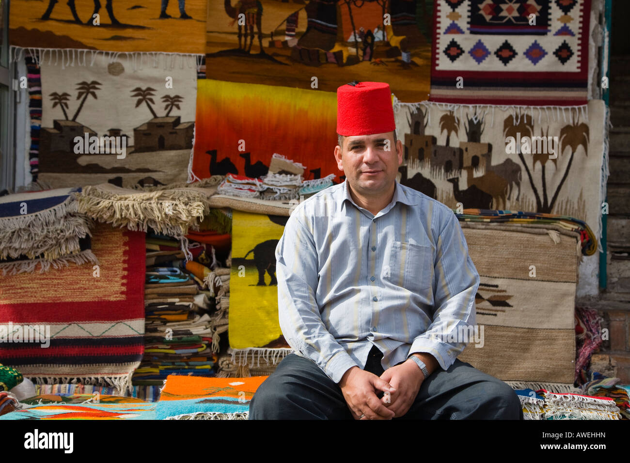 Uomo egiziano vendono tappeti nel Souk nel vecchio Sinai Sharm Egitto Foto Stock