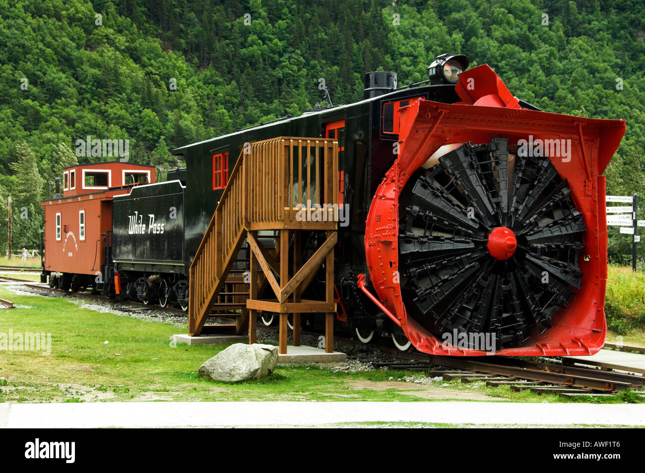 I pass di colore bianco e la stazione ferroviaria di Yukon presentano delle vetture del treno e un aratro di neve sulla strada principale di Skagway Alaska USA Foto Stock