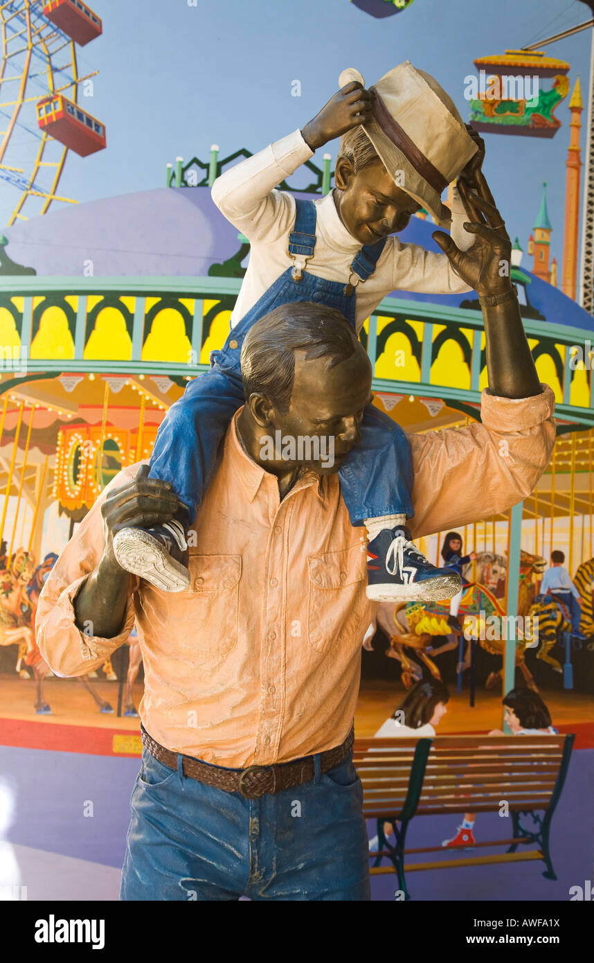 CALIFORNIA Santa Barbara Statua di uomo con ragazzo su spalle realistiche e di dimensione di vita realistico giostra colorati murali di arte pubblica Foto Stock