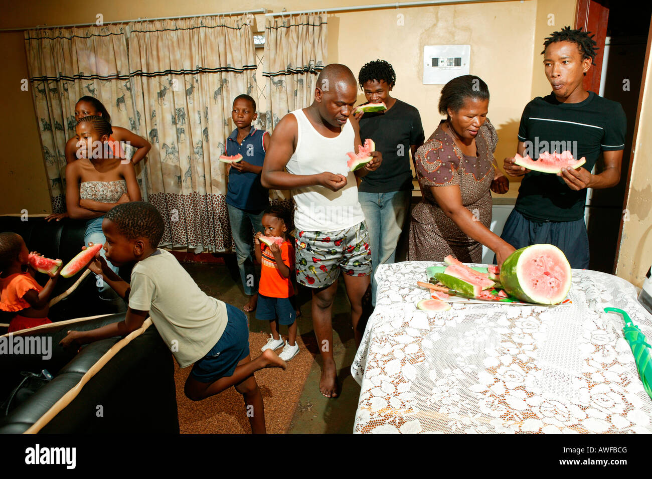 Famiglia estesa di mangiare il melone, Gaborone, Botswana, Africa Foto Stock