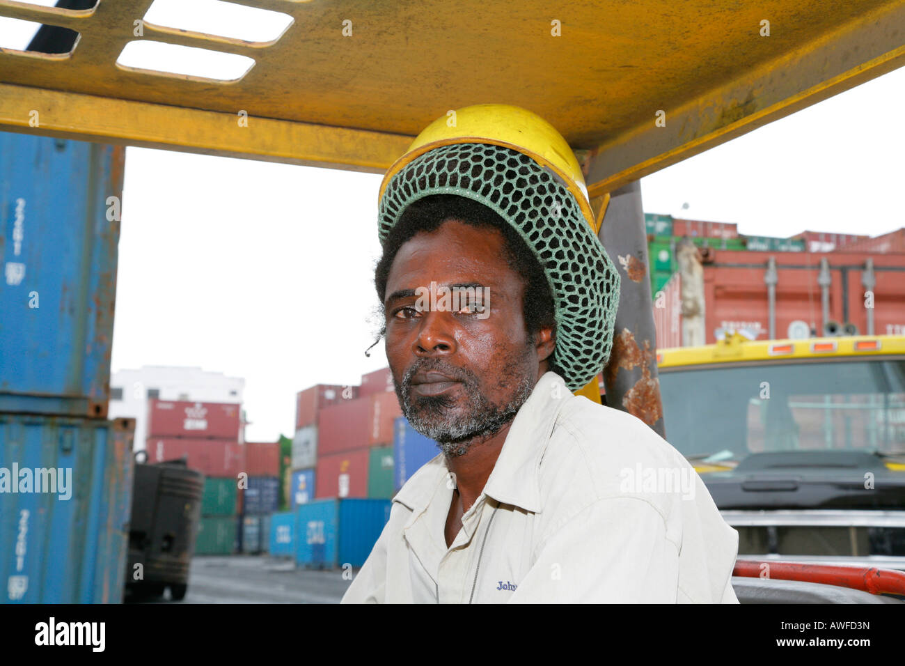 Dock Lavoratore che indossa hardhat oltre pinned-back dreadlocks a John Fernandes porto di trasbordo in Georgetown, Guyana, Sud Ameri Foto Stock