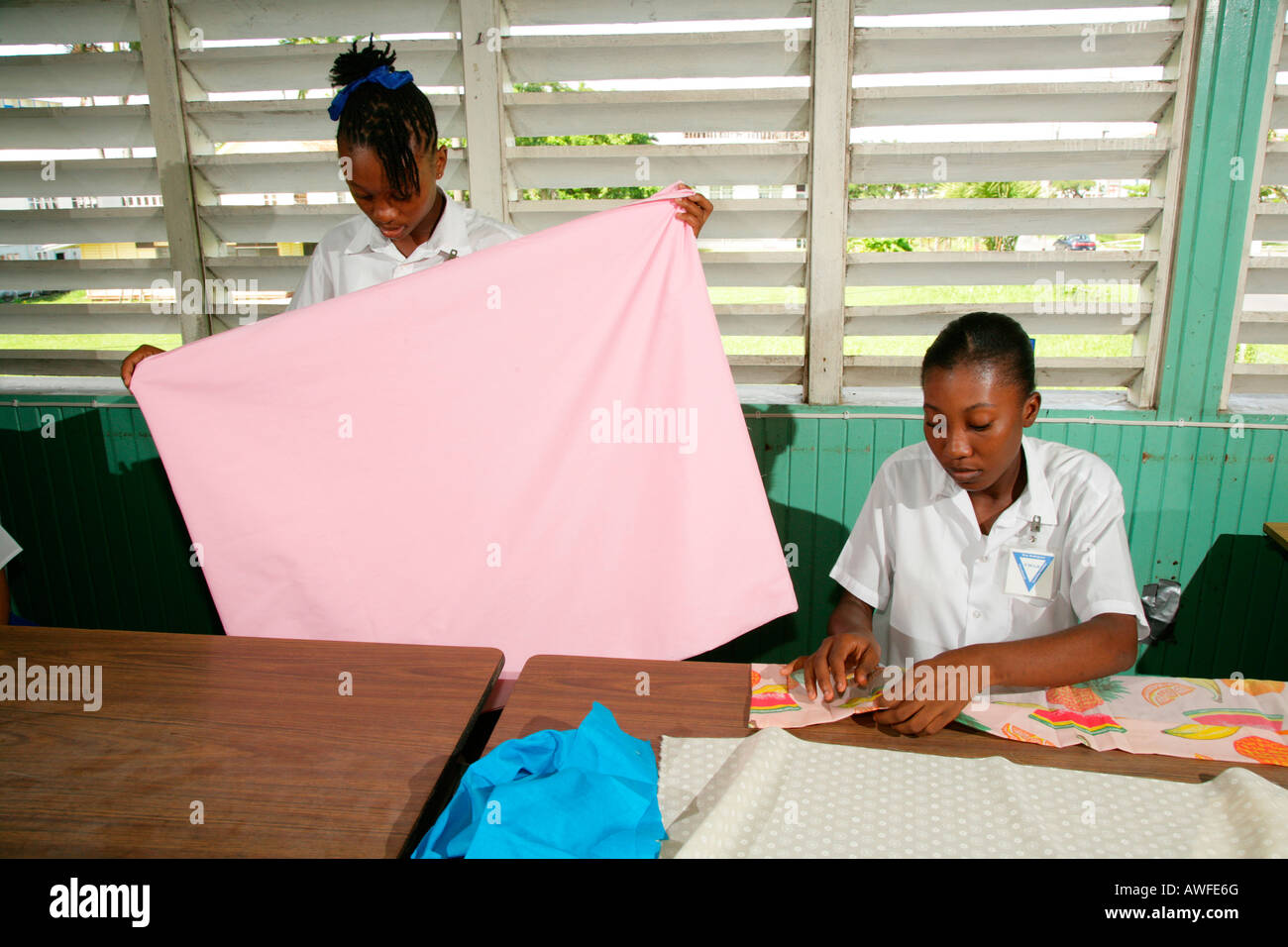 Le ragazze che indossano uniformi scolastiche nella classe di cucitura in corrispondenza di un centro di formazione per giovani donne in New Amsterdam, Guyana, Sud America Foto Stock