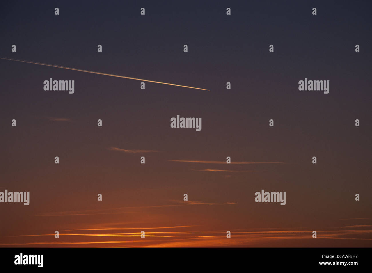 In inverno il cielo al tramonto, con aeromobili distanti e di vapore trail, Lincolnshire, Regno Unito. Foto Stock