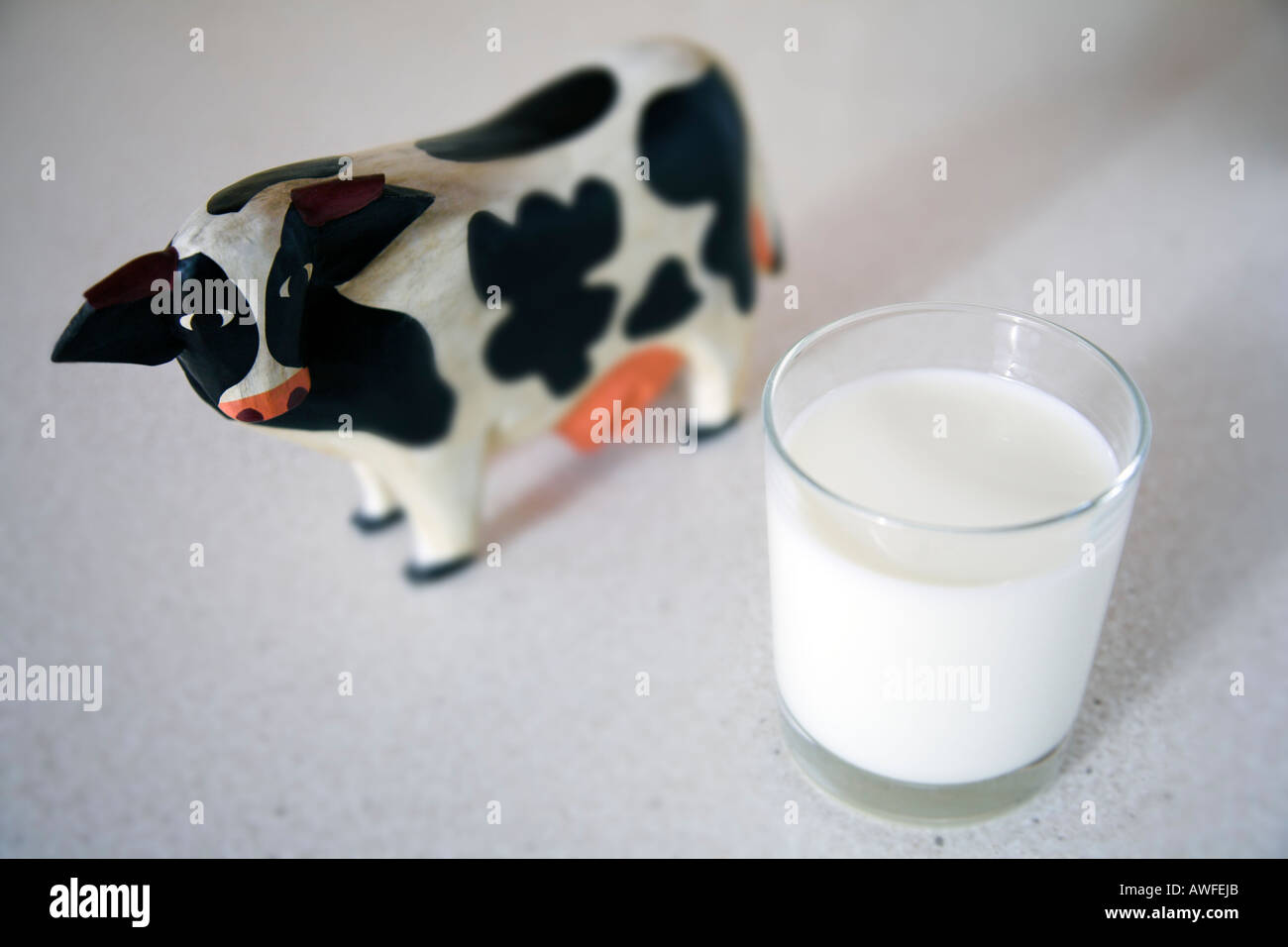 Giocattolo di legno di vacca e un bicchiere di fresco latte pastuerised Foto Stock