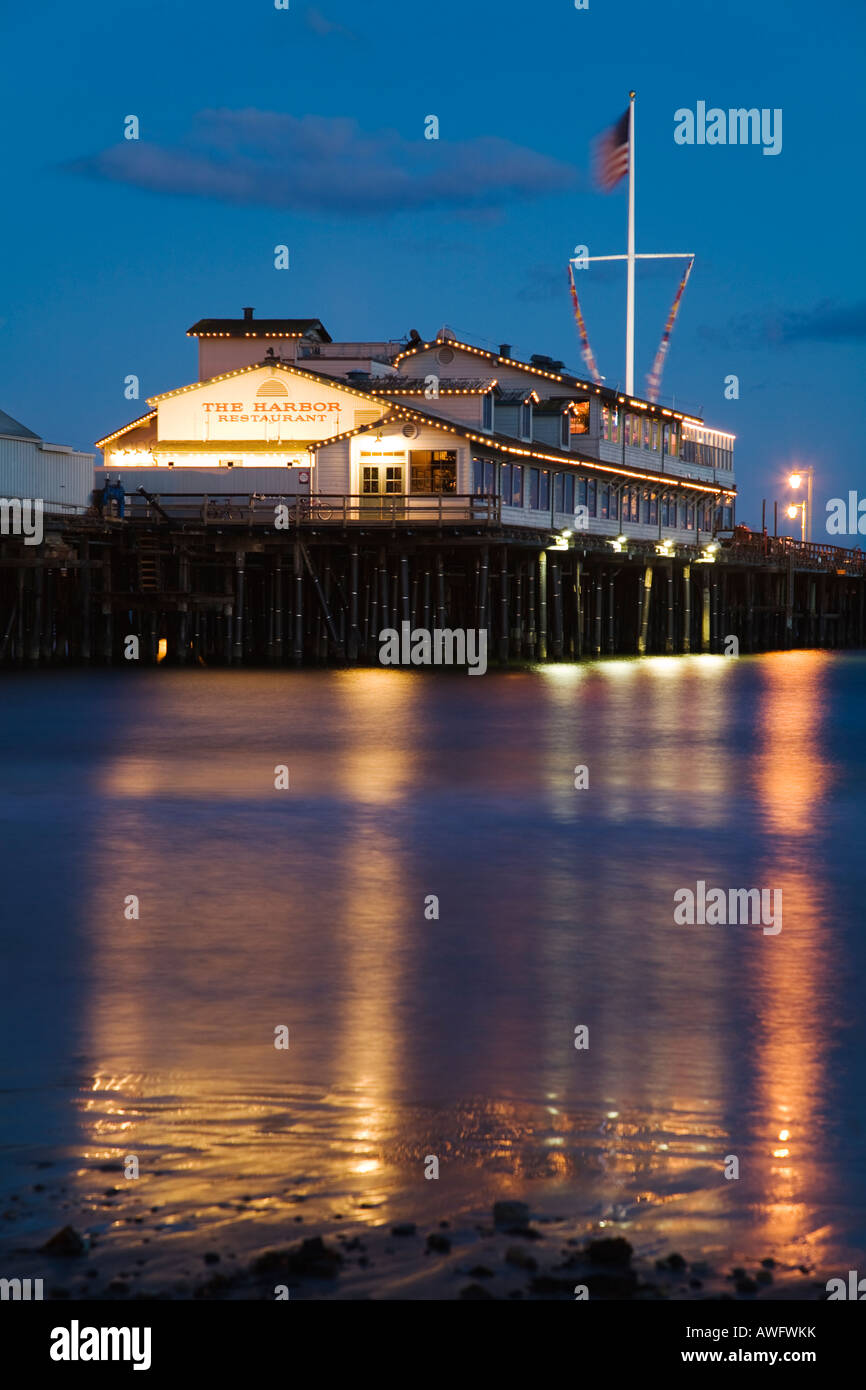 CALIFORNIA Santa Barbara Stearns Wharf pier si estendono nell'Oceano Pacifico Harbor Ristorante edificio al crepuscolo edifici e bandiera Foto Stock