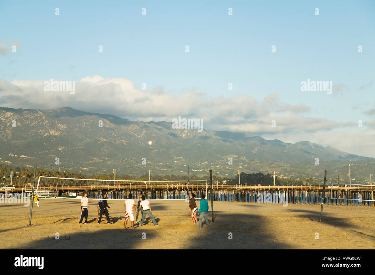 CALIFORNIA Santa Barbara di alta scuola gli studenti a giocare a beach volley sulla spiaggia occidentale Stearns Wharf e le montagne sullo sfondo Foto Stock