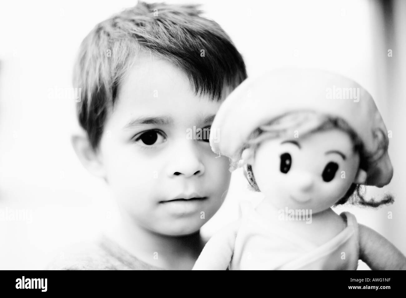 Ragazzo giovane trattiene una bambola Modello rilasciato il tasto alto alto contrasto immagine in bianco e nero per il drammatico impatto Foto Stock