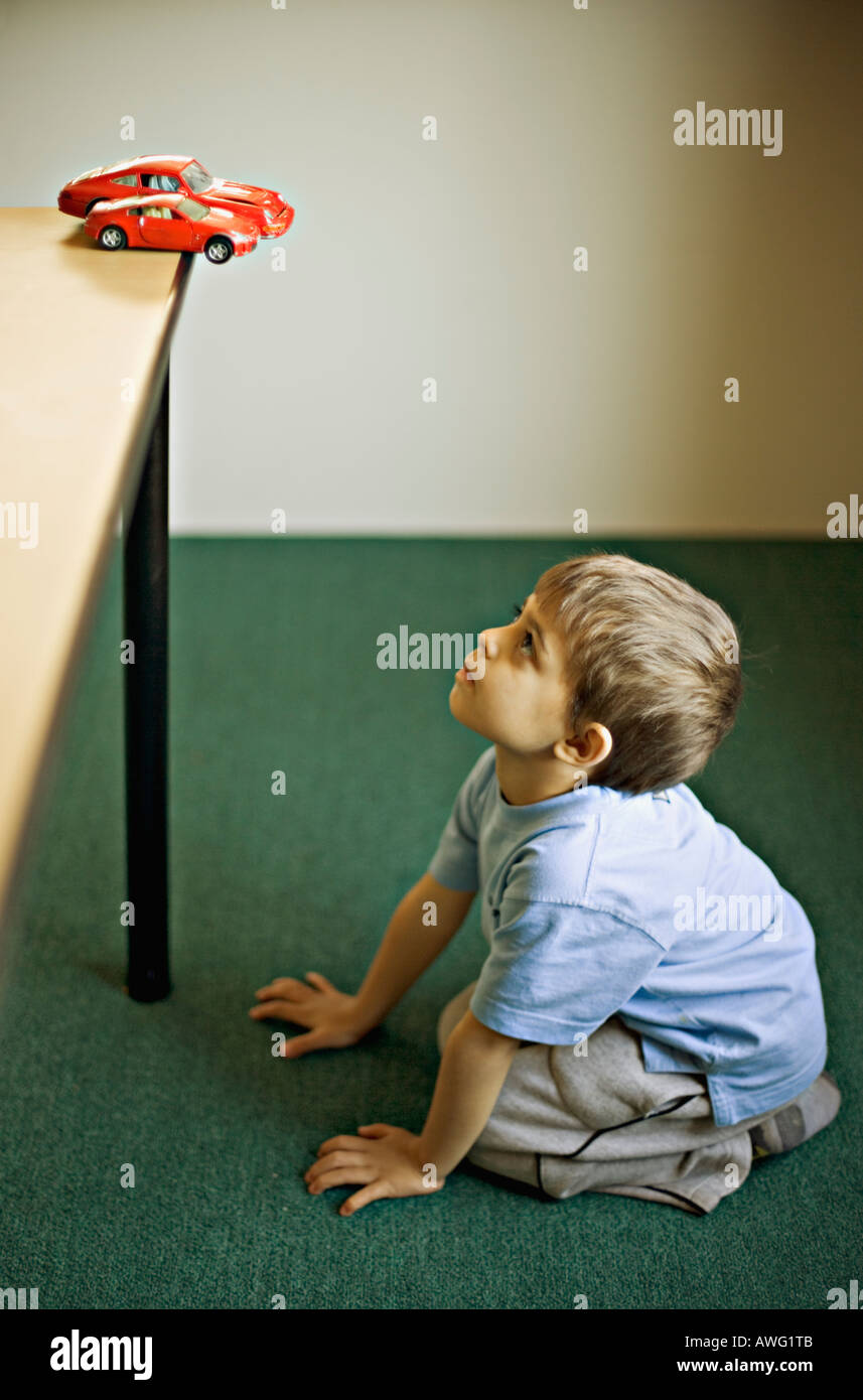 Bambino il desiderio di un automobile sportiva rossa quando cresce fino Foto Stock