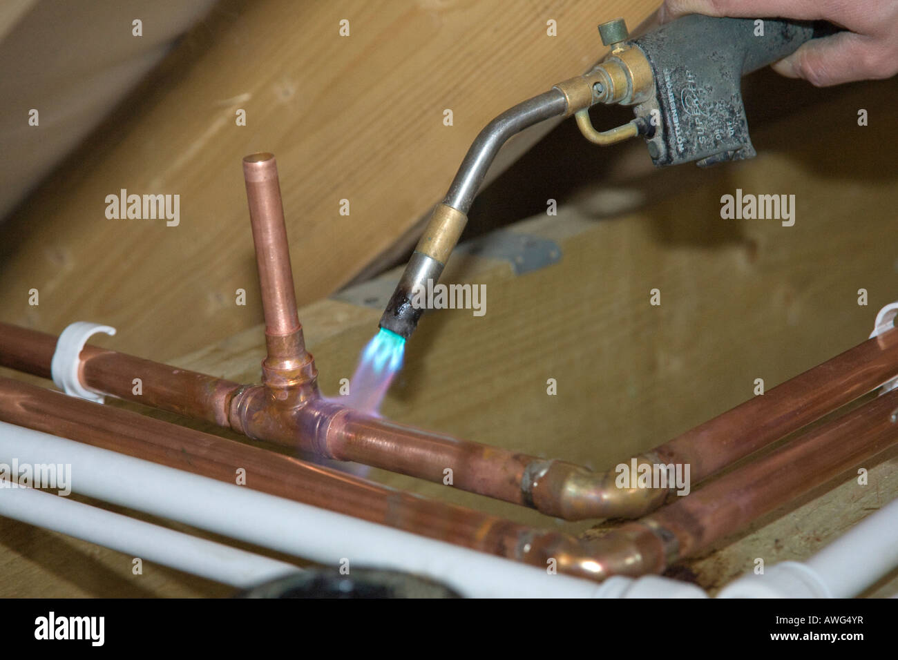 Un idraulico la saldatura di tubi in una nuova casa Foto Stock
