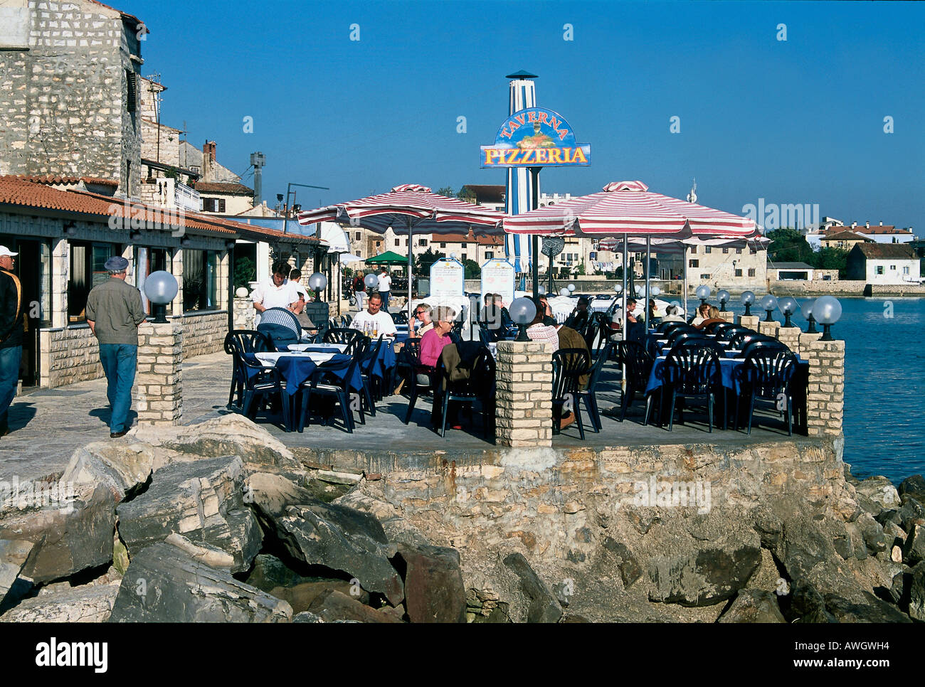 Croazia, Umago (Umago), persone seduti ai tavoli esterni del lungomare Taverna Pizzeria Foto Stock