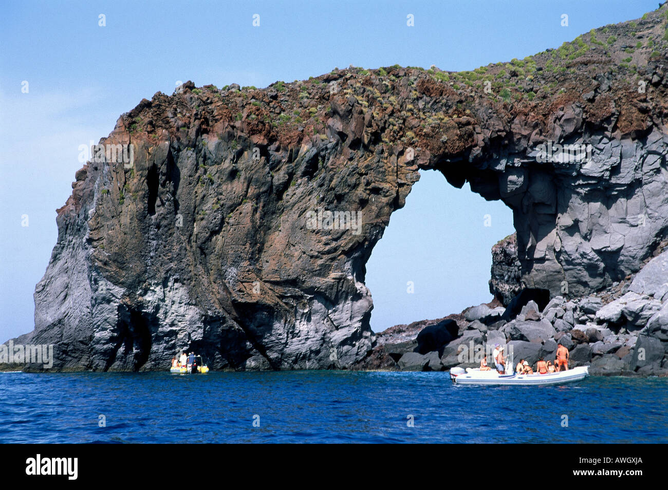 L'Italia, Sicilia e Isole Eolie, Salina, Perciato di Pollara, visitatori nel piccolo battello motorizzato Foto Stock