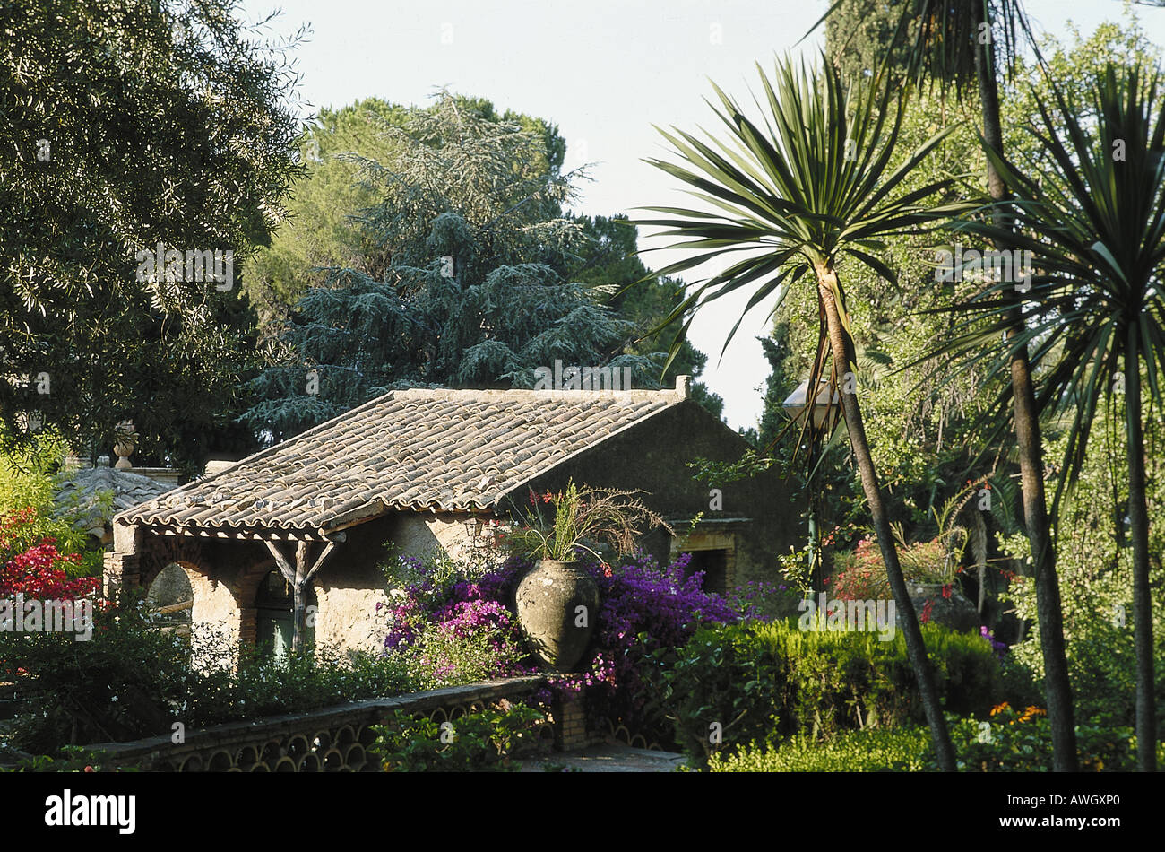 L'Italia, in Sicilia, a nord-est della Sicilia, Taomina, tetto di tegole edificio, giardini pubblici con palme e piante esotiche Foto Stock