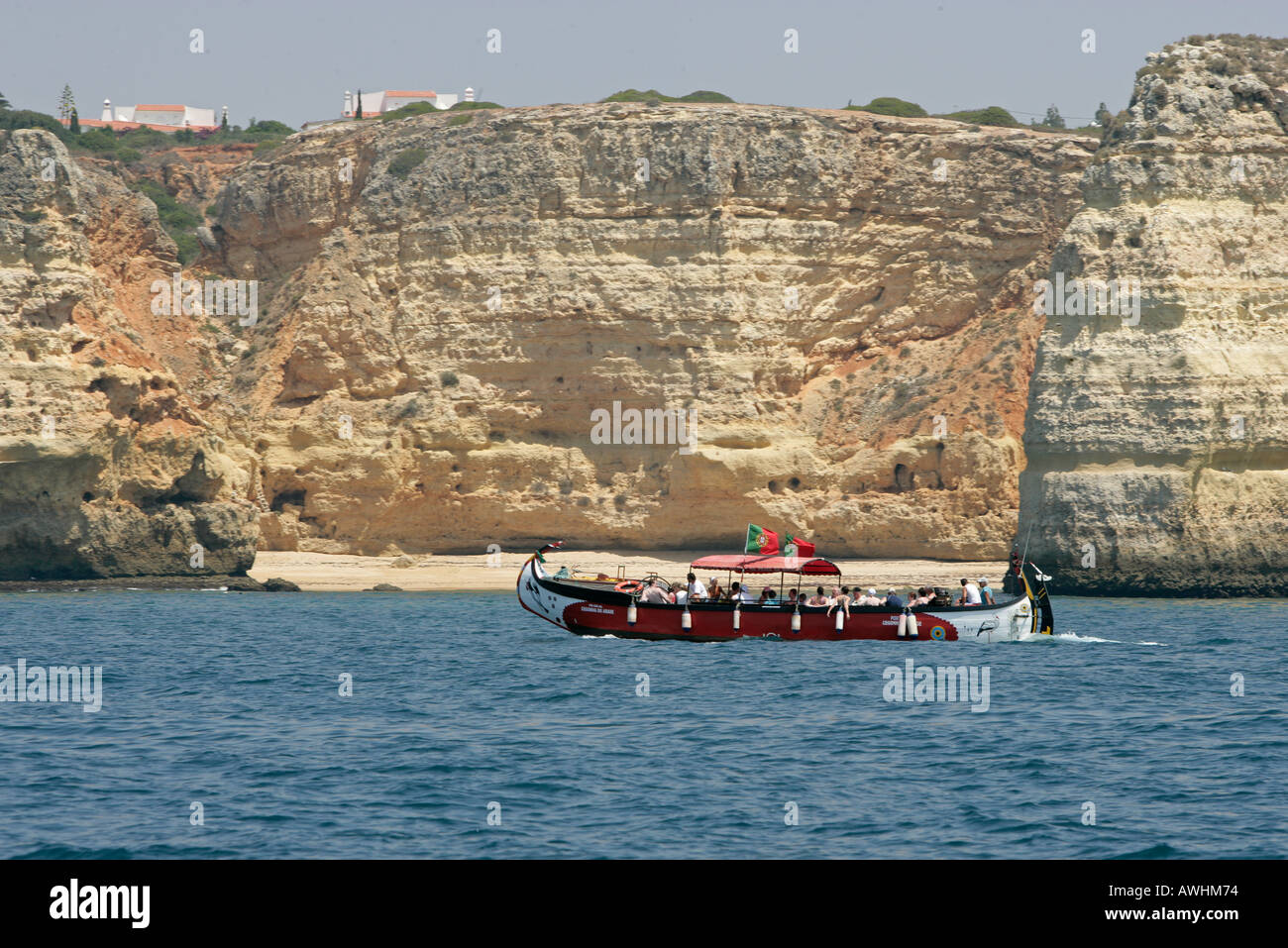 Un portoghese tour in barca con una forma tradizionale di motori di scafo passato spiagge e scogliere lungo la costa Algarve Foto Stock