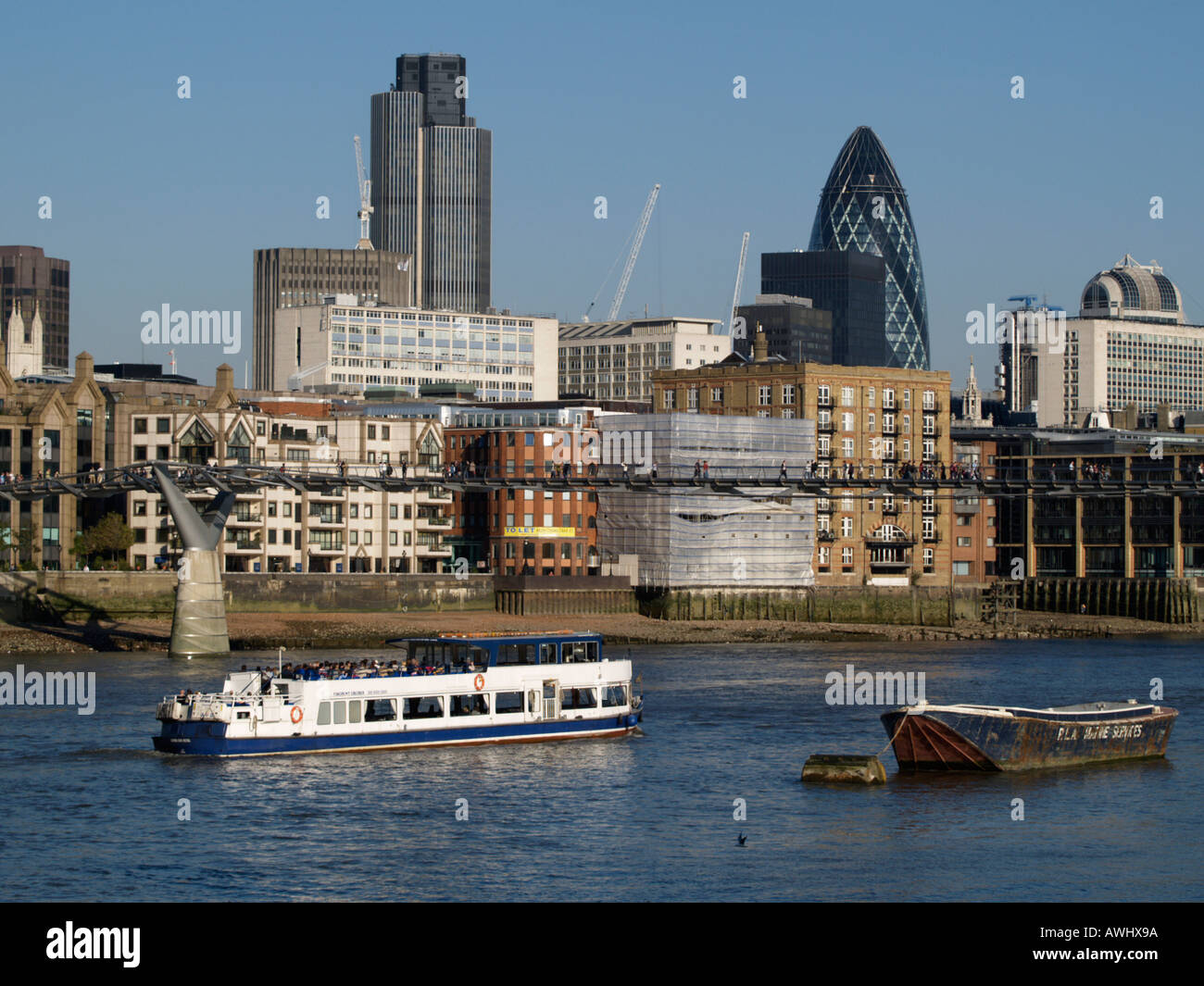 Skyline della città di Londra il quartiere finanziario con millennium ponte pedonale e turismo barca sul fiume Thames Regno Unito Foto Stock