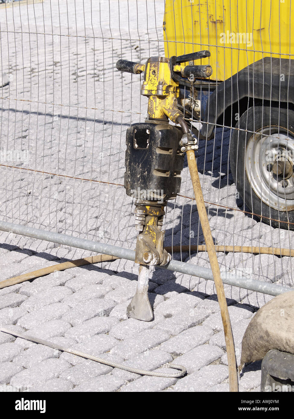 Jackhammer, trapano pneumatico quaresima contro un recinto di filo. Foto Stock