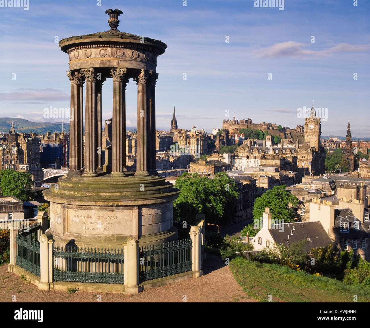 Edimburgo, Scozia, Regno Unito. Il Dugald Stewart monumento su Calton Hill, con vista dello skyline della città tra cui il castello di Edimburgo Foto Stock