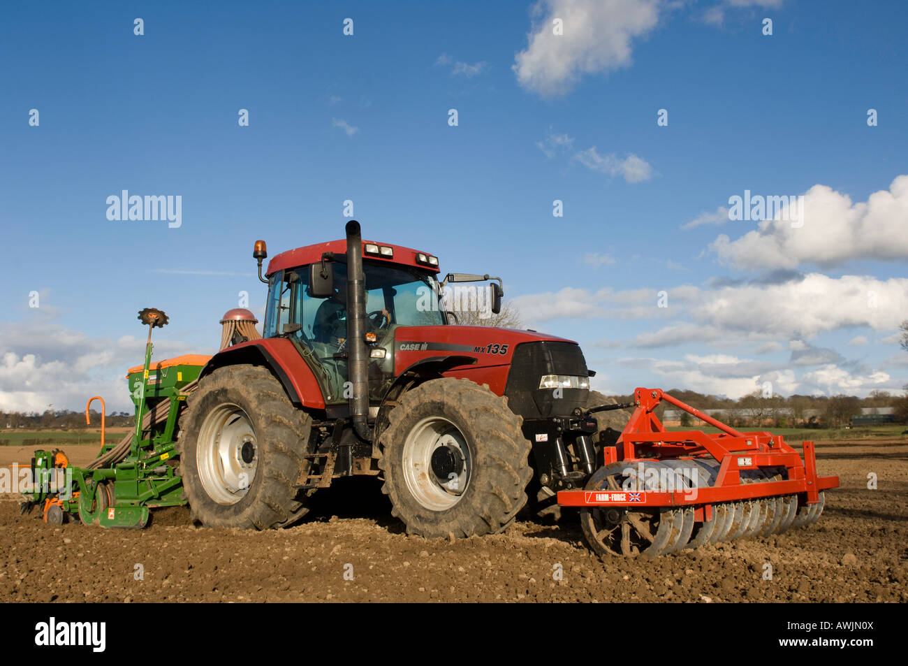 Il contadino semina di fagioli con un sistema pneumatico della seminatrice montata su un caso trattore Maxxum montate anteriore con dischi montati Foto Stock