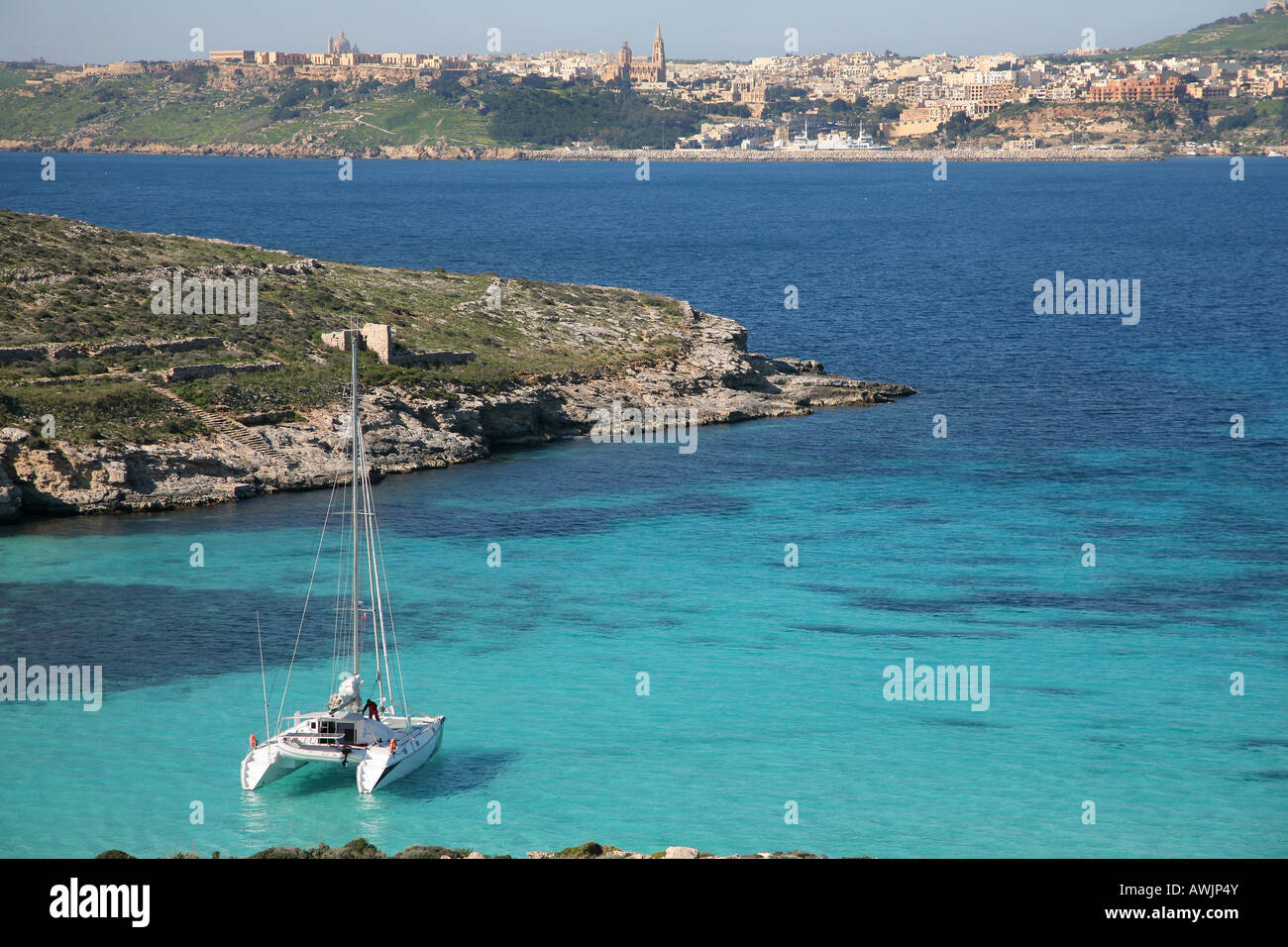 Un catamarano in alla Laguna Blu di Comino Isola di Malta Gozo può essere visto in background Foto Stock