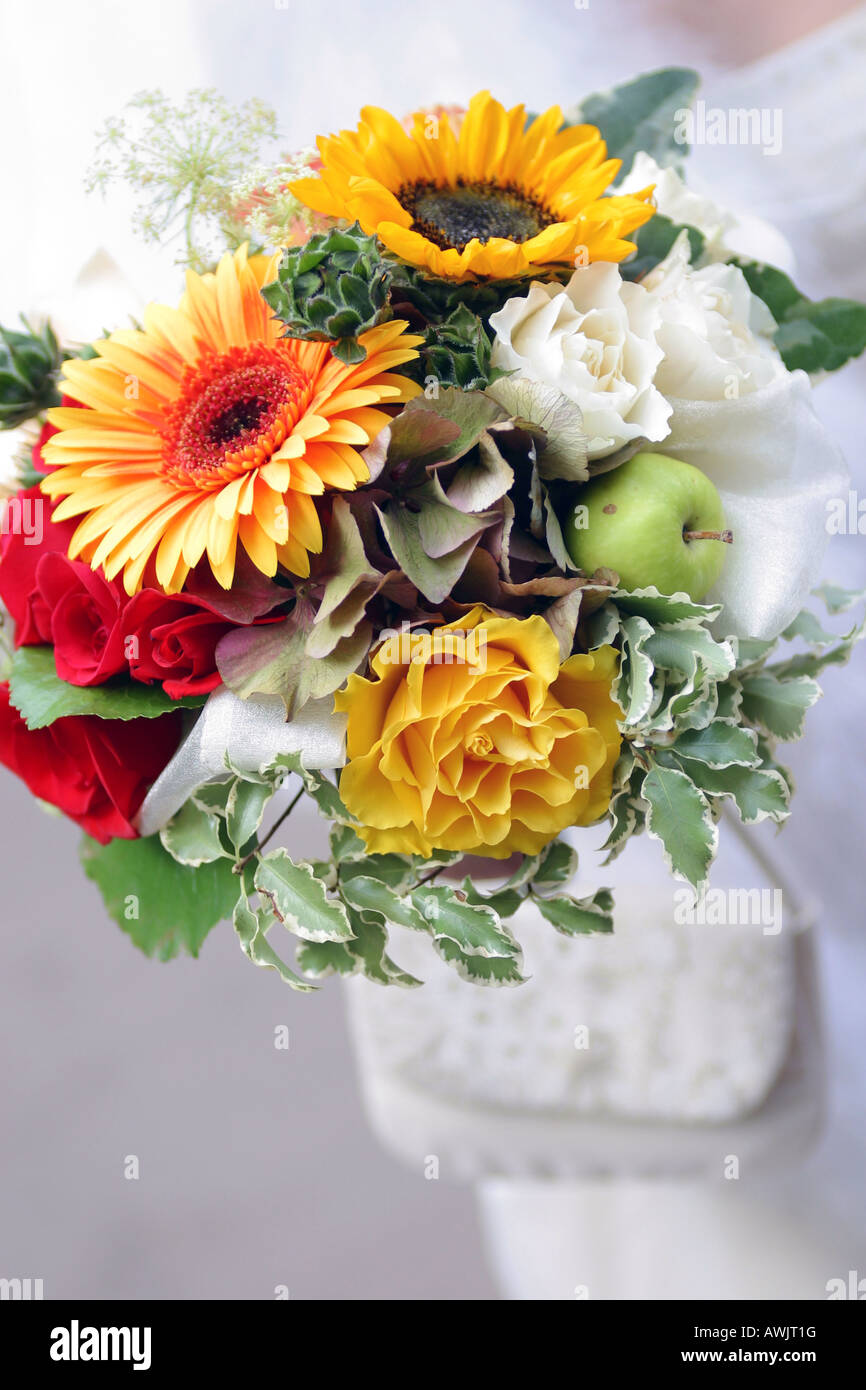 Un ritratto di un bouquet di fiori belli essendo trattenuto da una sposa in un tradizionale abito bianco il giorno del matrimonio Foto Stock