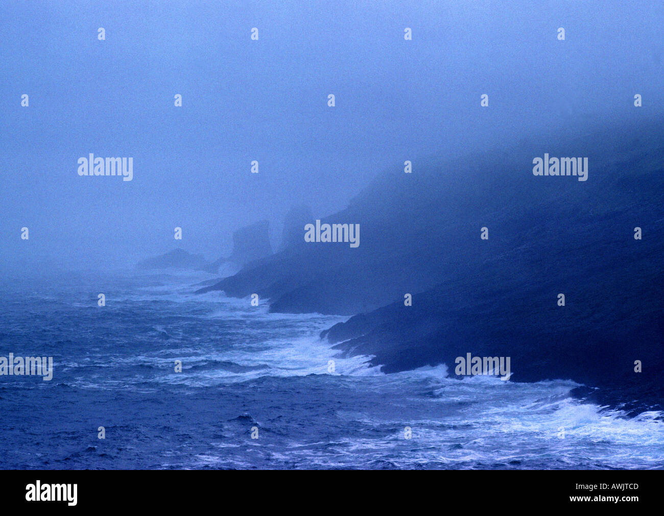 Onde costa colpire nella nebbia Foto Stock