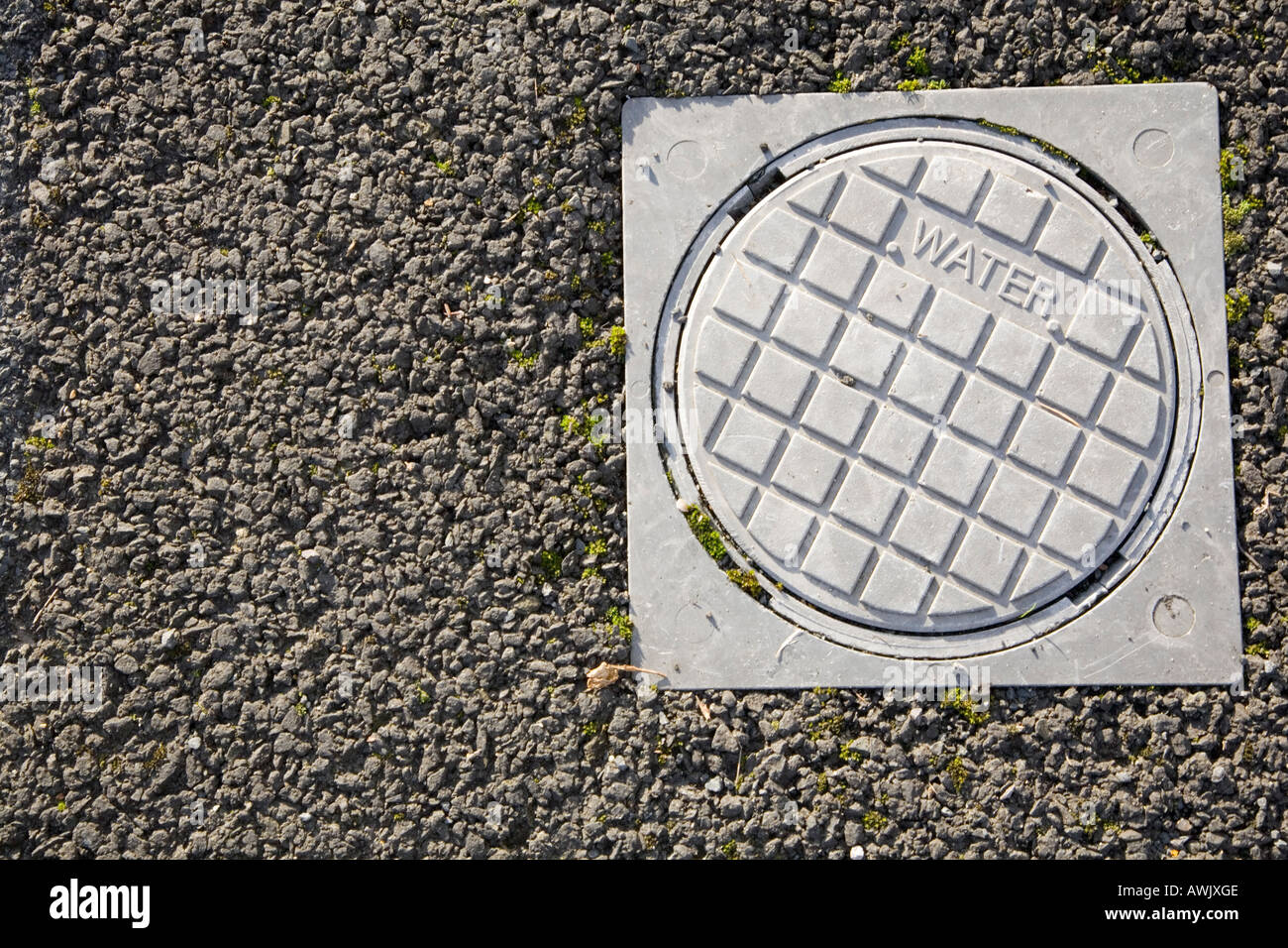 Acqua coperchio di accesso su un asfalto marciapiede Foto Stock