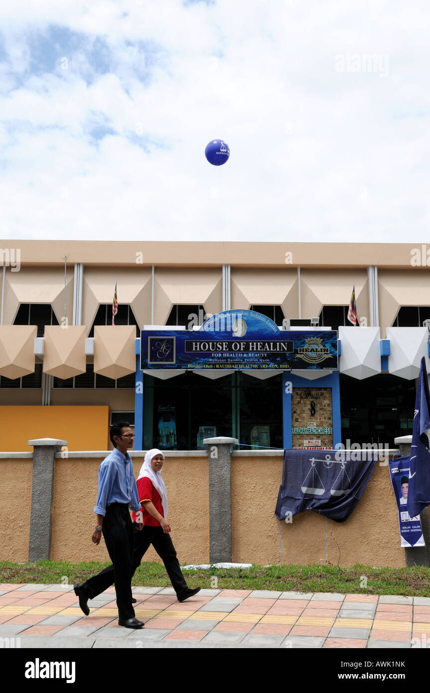 Due signore camminare davanti a un centro di polling a Kuala Lumpur in Malesia Foto Stock