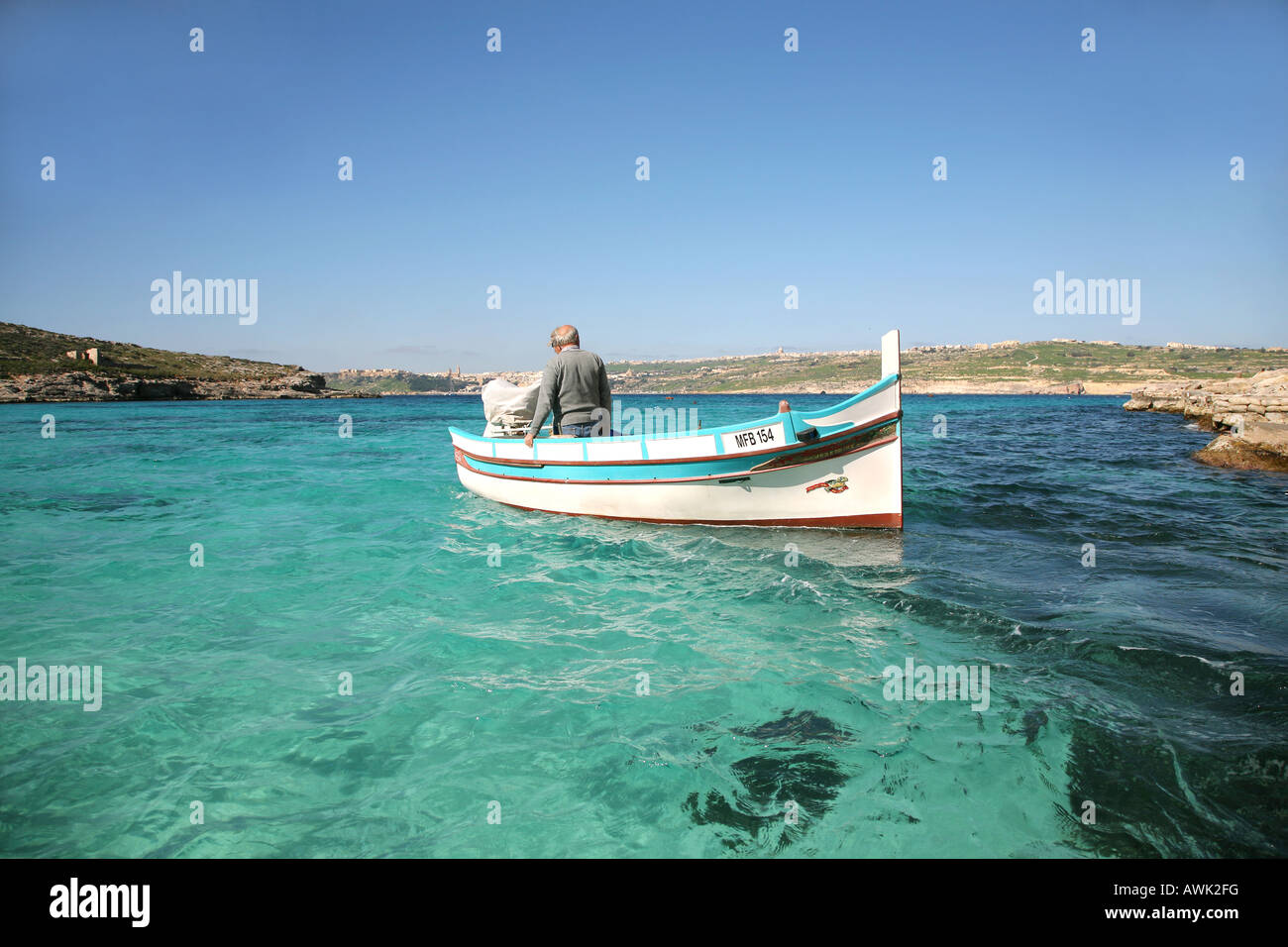 Un pescatore locale dell isola di Comino parte di Malta Gozo può essere visto in background Foto Stock