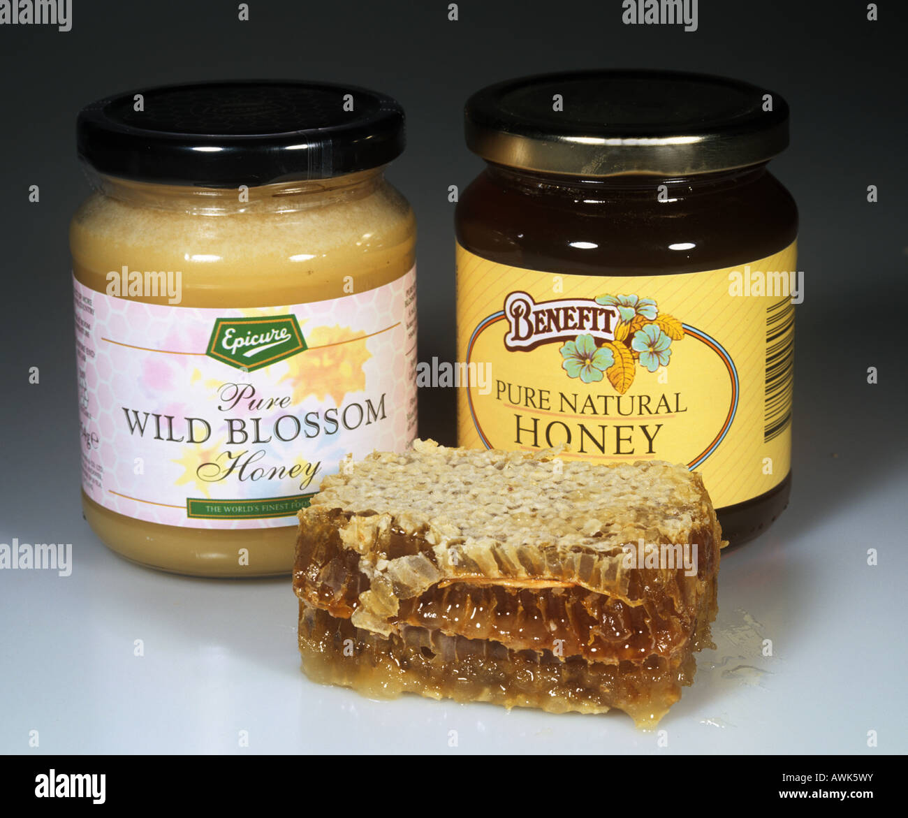 Vasi di trasparente e opaco di miele con una fetta da un pettine dall'alveare Foto Stock