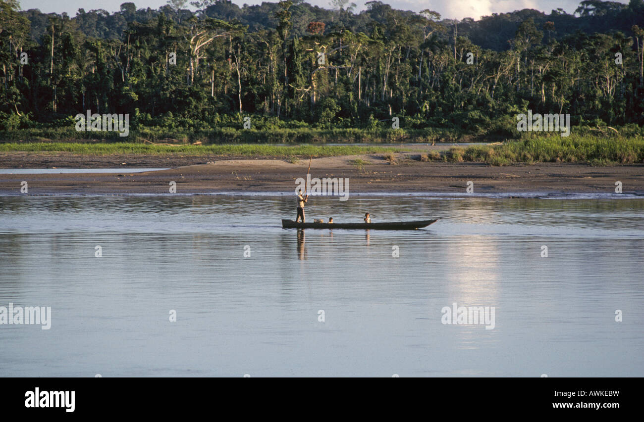 Un pescatore indiano poli una piroga verso un fiume nella foresta di pioggia nella parte a nord del Parco Nazionale del Manu Perù Foto Stock